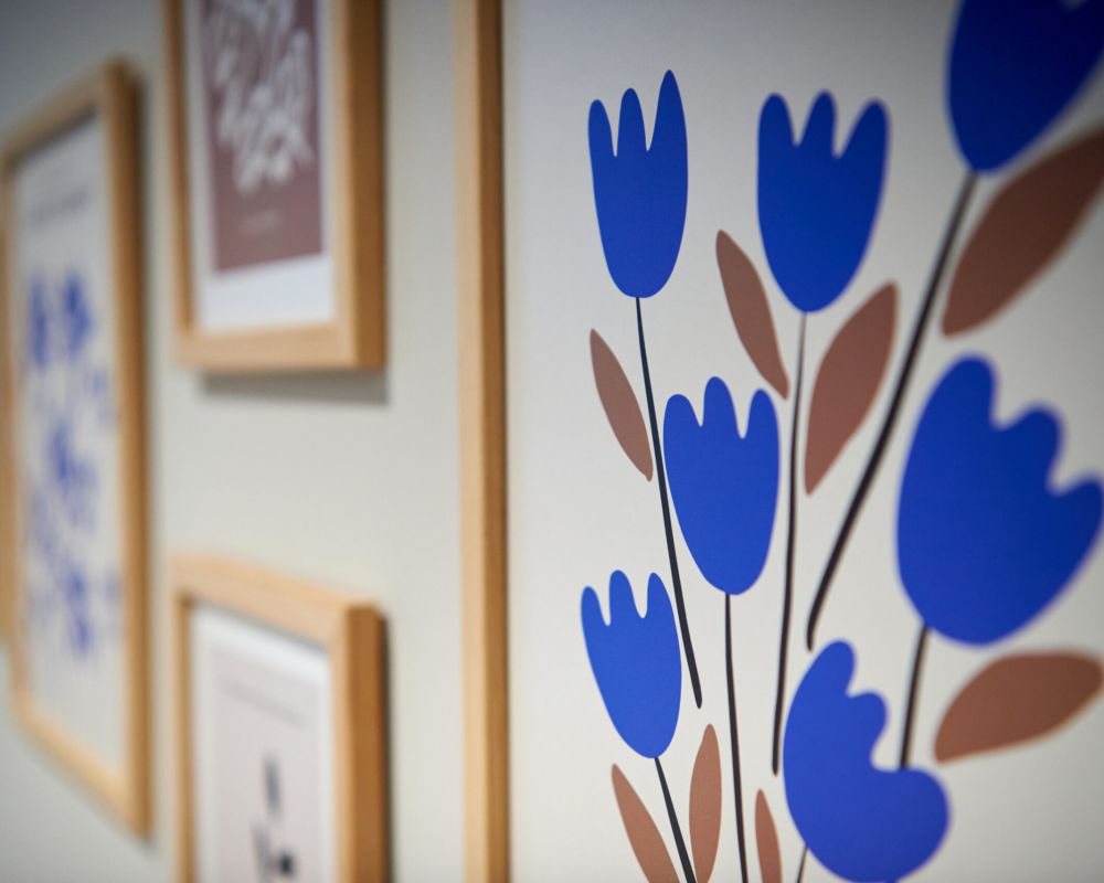 Framed wall art at VERVE Columbus featuring minimalist floral illustrations with bold blue tulips and earthy brown stems—adding a playful, modern touch to the interior decor.