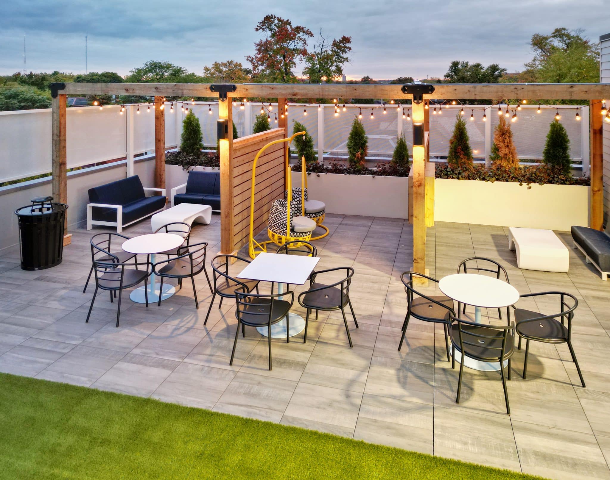 The Verve Columbus student apartments outdoor lounge with couches, eating tables, and TVs, alternate view