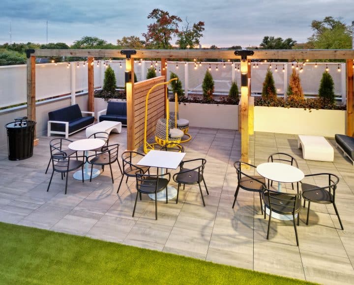 The Verve Columbus student apartments outdoor lounge with couches, eating tables, and TVs, alternate view